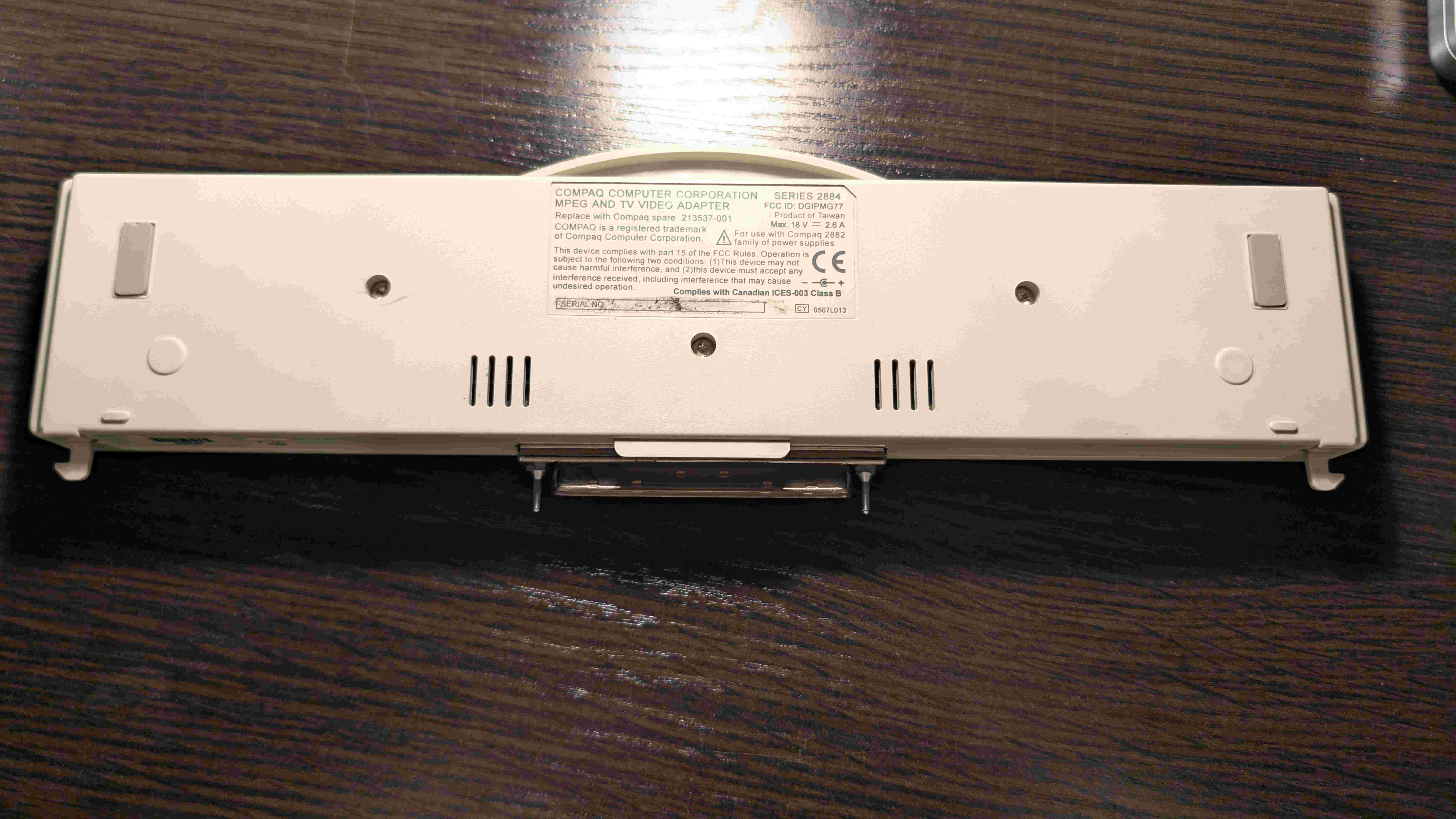 Bottom view of the Compaq adapter showing the specification sticker with 18V 2.6A power rating